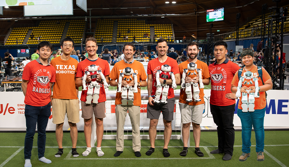 The WisTex United team members stand on a green field after winning the Challenge Shield Division at RoboCup 2024.