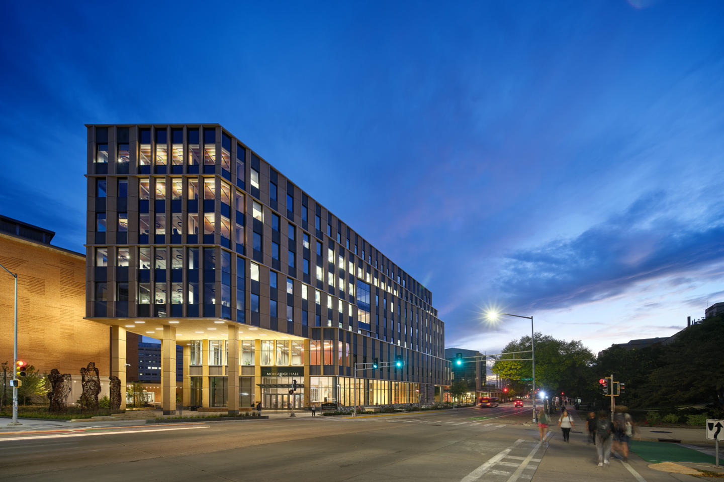 View of Morgridge Hall at twilight, with lights on in the building